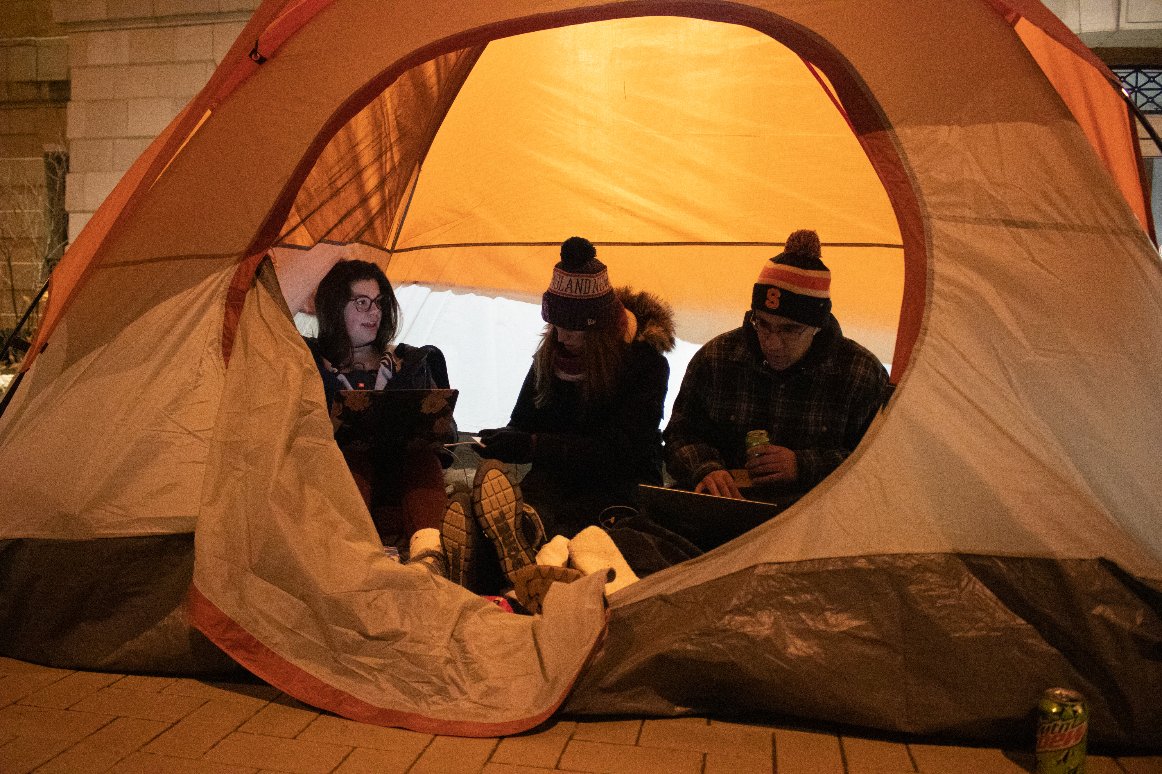 Syracuse freshmen Emma Sheridan, Anna Blackwood, and Chris Bezdedeanu work on homework in their tent during the Carrier Dome Camp Out before the Syracuse Men's basketball game against Duke on the night of January 31, 2020.