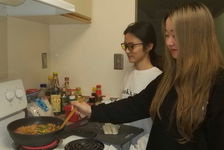 Lubeini Yang and Suyun Chen cook in their south campus apartment