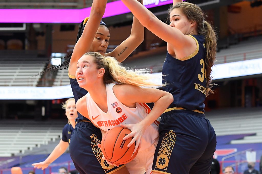 Jan 31, 2021; Syracuse, New York, USA; Syracuse Orange forward Digna Strautmane (45) controls the ball between Notre Dame Fighting Irish center Mikayla Vaughn (left) and forward Madelyn Westbeld (34) during the first half at the Carrier Dome. Mandatory Credit: Rich Barnes-USA TODAY Sports
