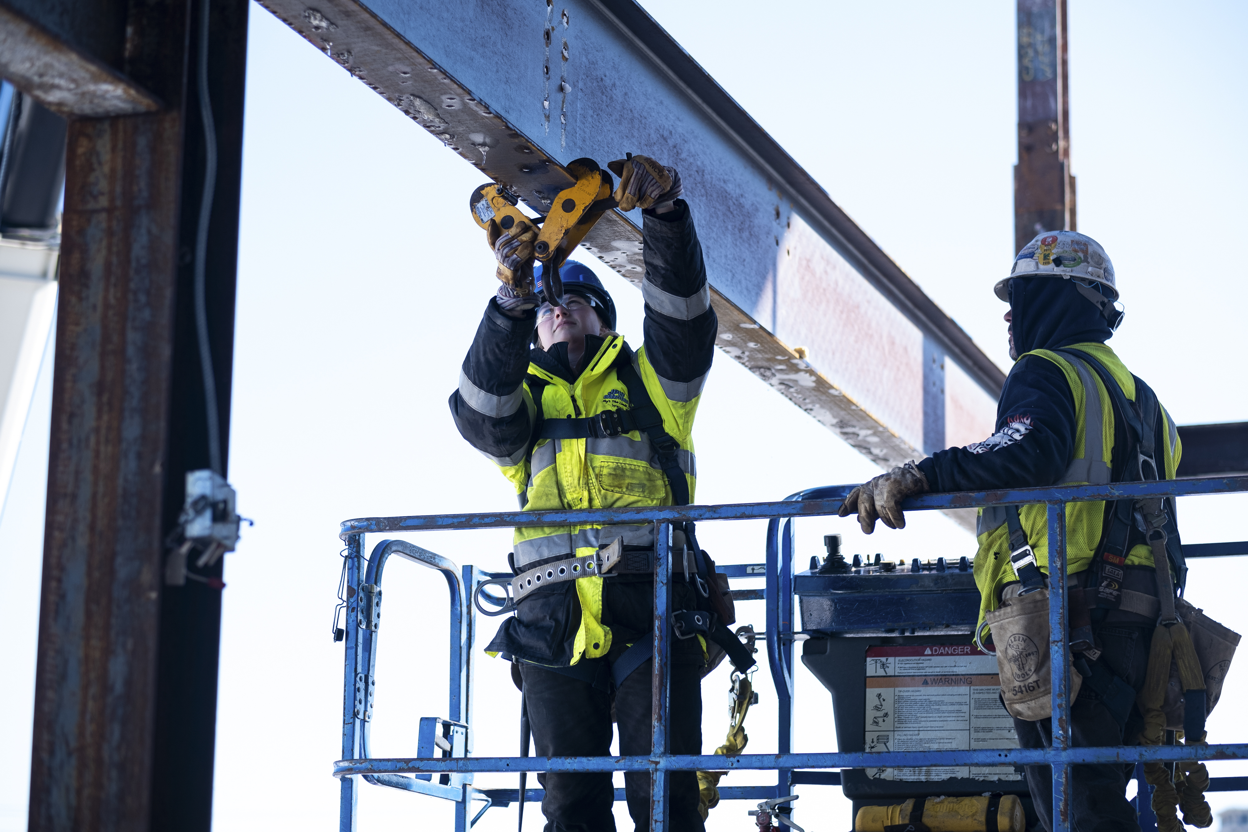 Alivia Allen places a beam clamp that will help hold the weight of the iron beam while it is being moved into place.