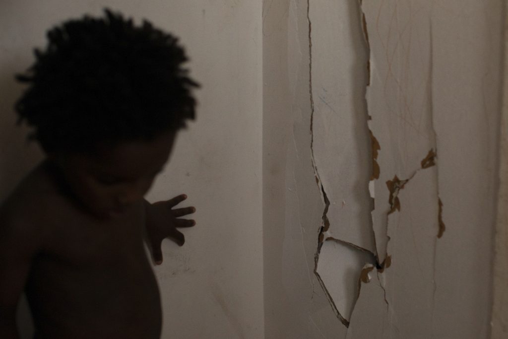 Darlene touches a broken wall that split when her three-year-old twins were playing against it.