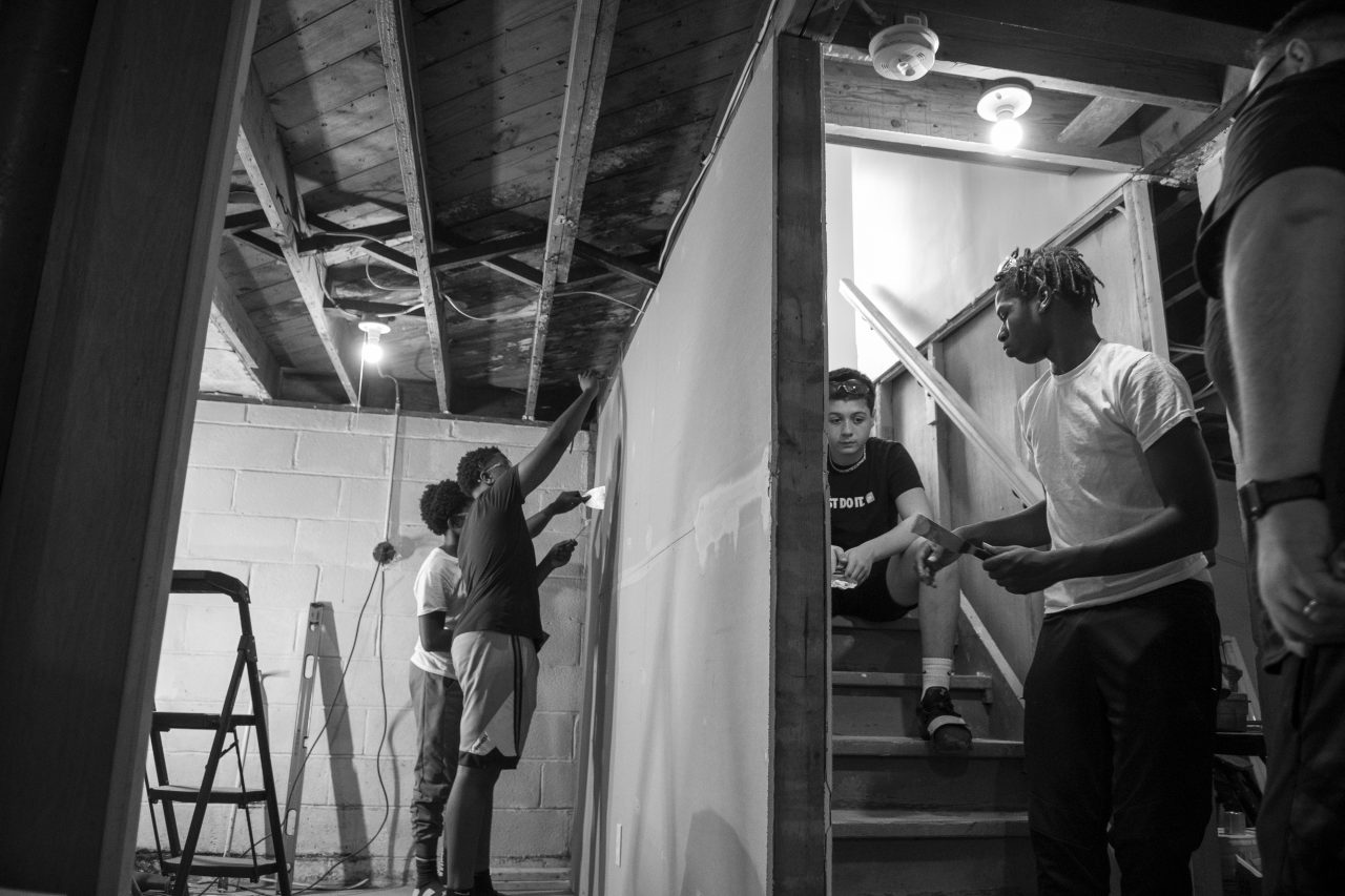 Jimere Ellerby and Brian Hall (left) continue working on drywalling while Steyvon Jones and Jaden Peña rest (right).