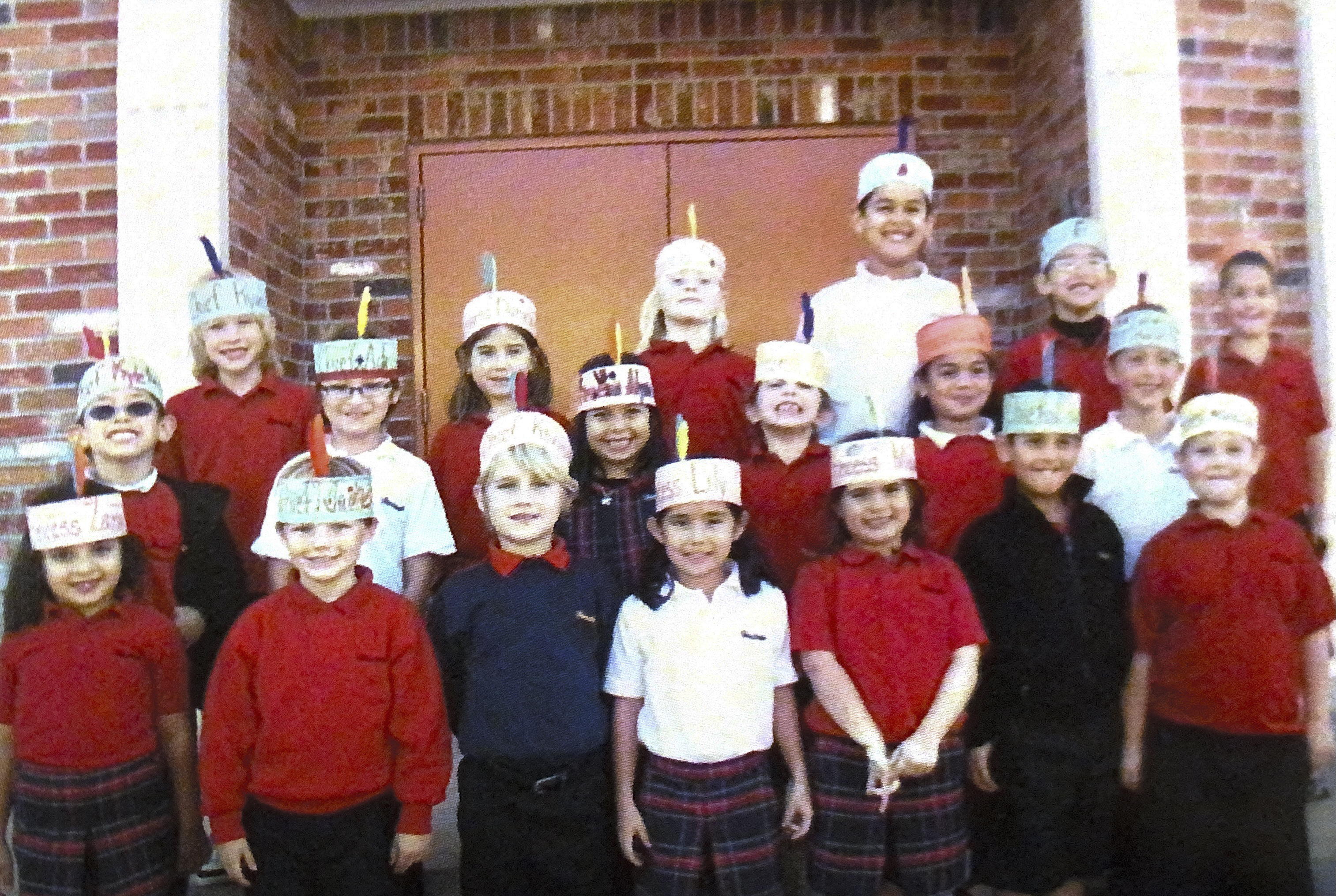 Alycia Cypress (middle) and her elementary school classmates wearing feather headbands in order to pose as Native Americans for an annual Thanksgiving lunch.