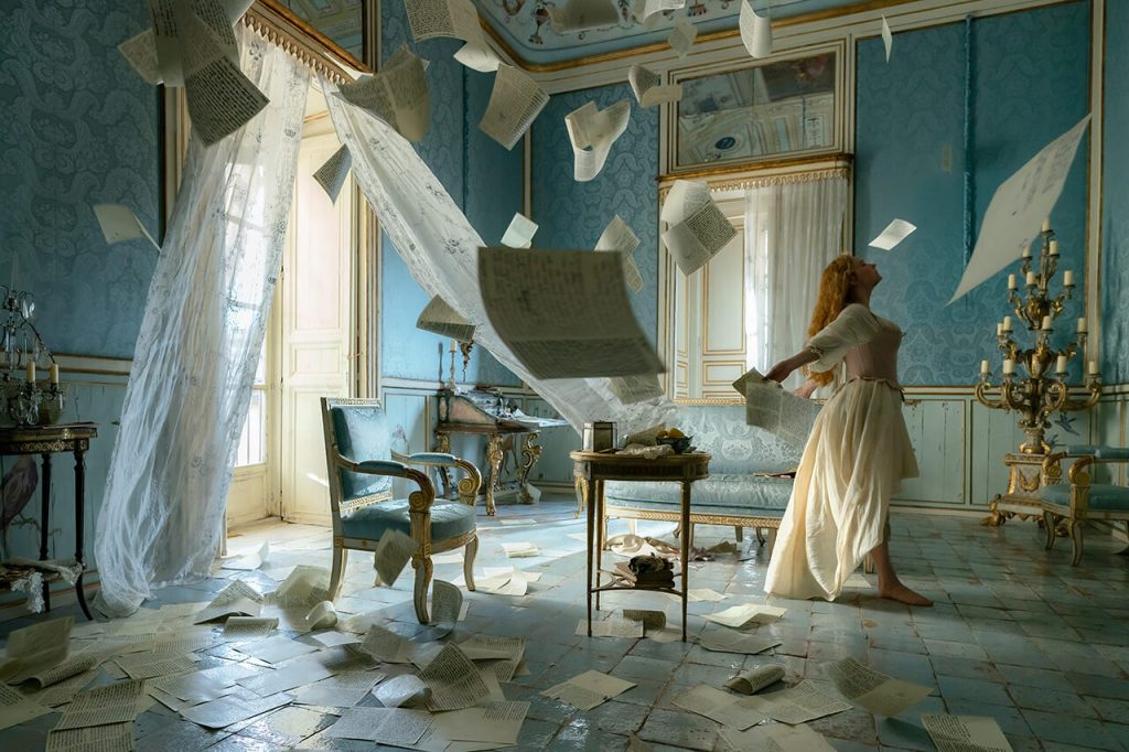 Roxanne walks through swirling love letters in a pastel blue bedroom.