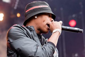 Rapper Lil Baby performs on stage in a bucket hat and diamond bracelet.