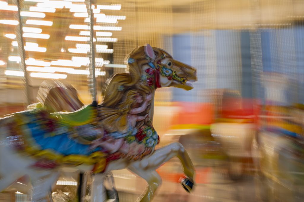 Classic rides like the Merry-Go-Round glow at night during the New York State Fair, creating a nostalgic sight. T