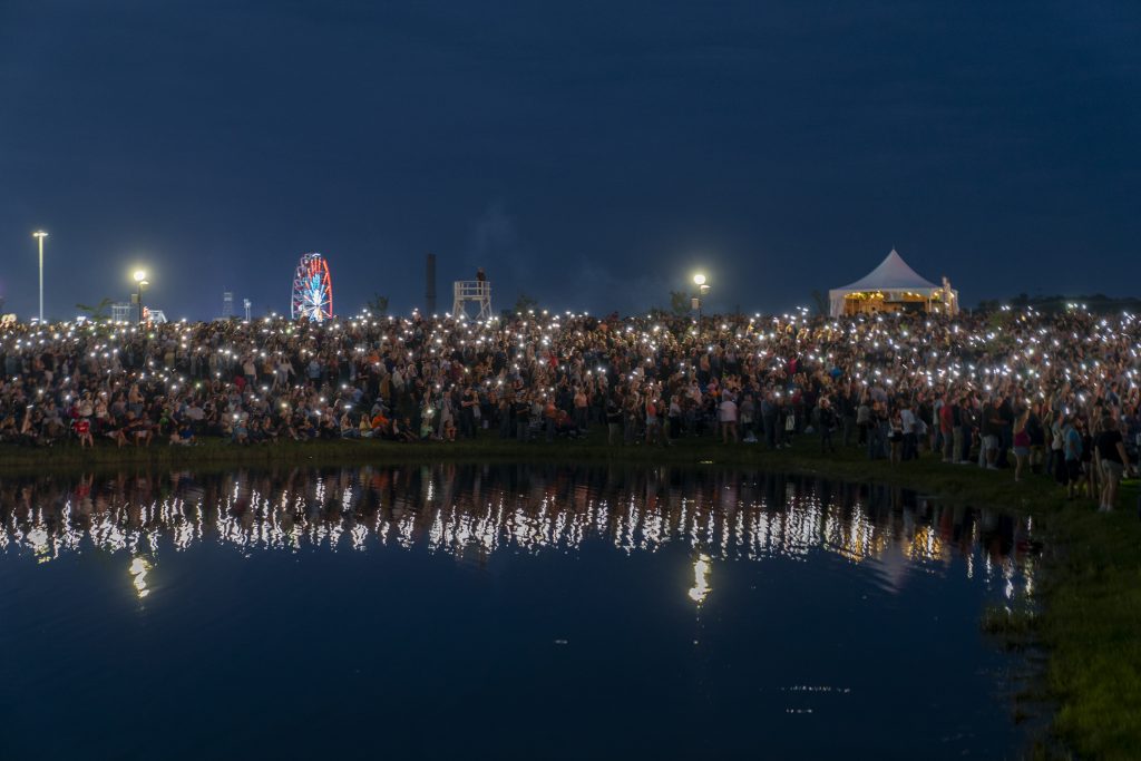 People hold up there phones and sing along to Lainey Wilson's 'Watermelon Moonshine' at Suburban Park in the New York State Fair on Wednesday August 25, 2023.