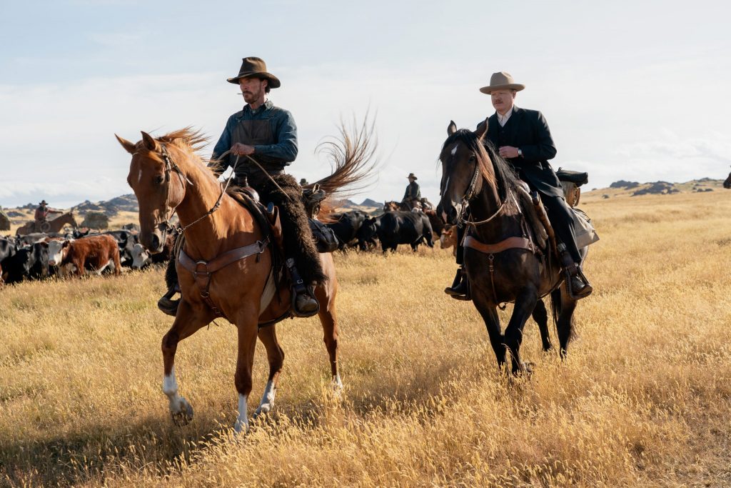 BENEDICT CUMBERBATCH as PHIL BURBANK, JESSE PLEMONS as GEORGE BURBANK ride horses in THE POWER OF THE DOG