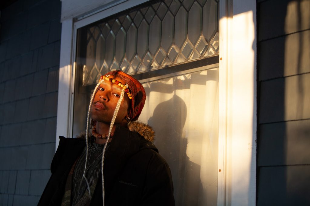 Ares Taylor poses in front of their house while sun hits their face