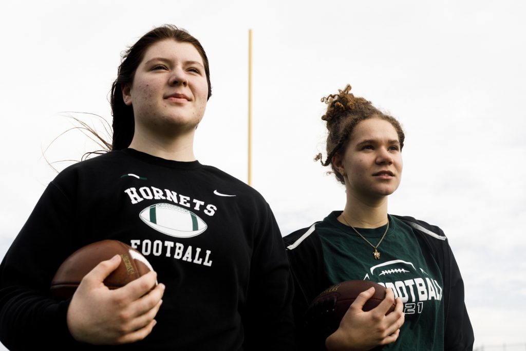 McBride and Leary standing with footballs on the field