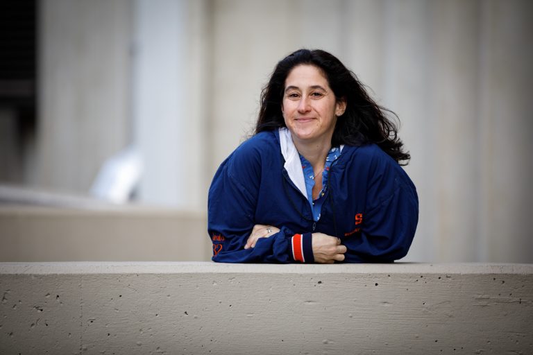 Alexis Sander poses for a portrait in her lacrosse jacket in front of the Dome