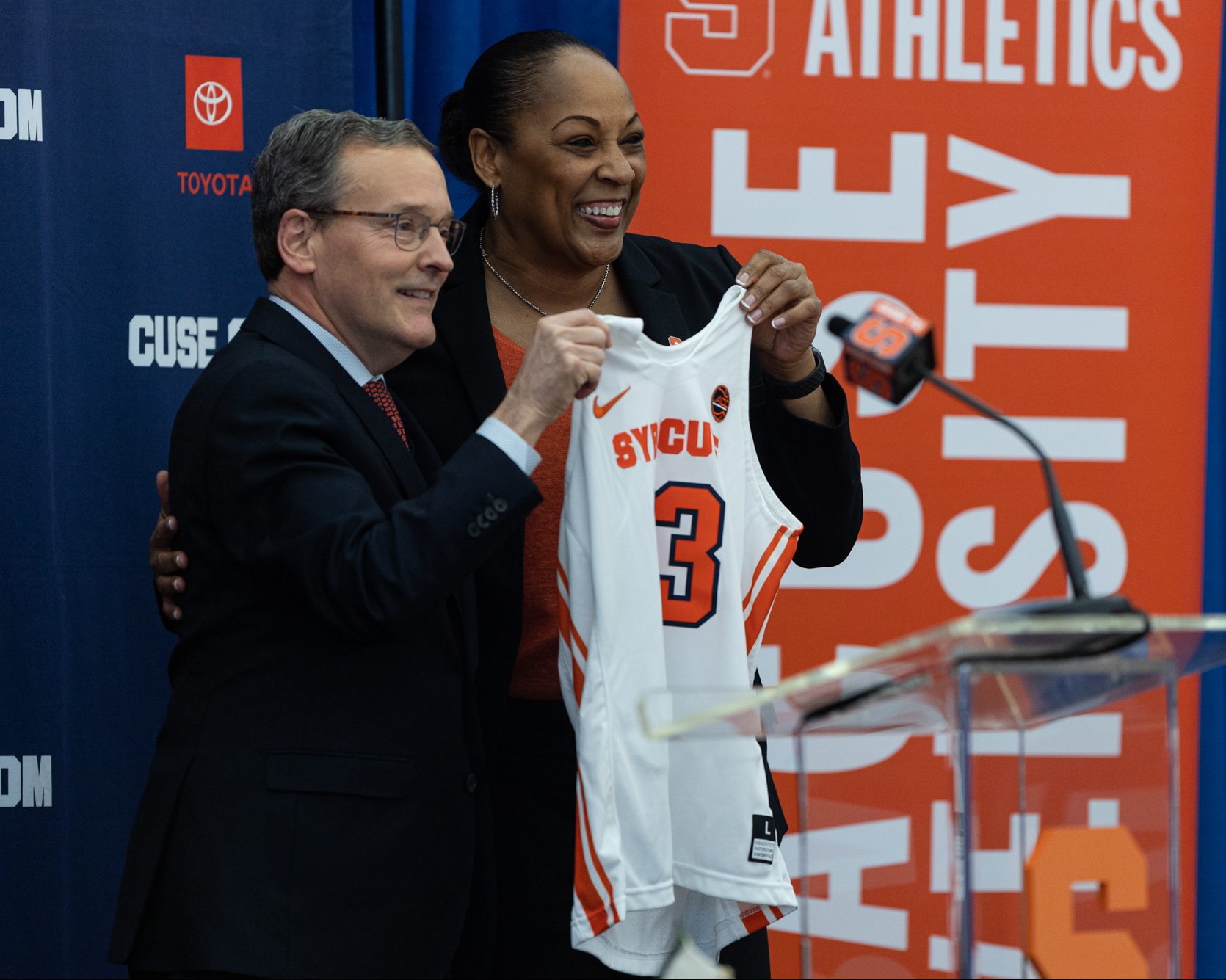 Felisha Legette-Jack and SU athletic director John Wildhack hold up a jersey with Felisha's name on it in the Melo Center on March 28th, 2022.