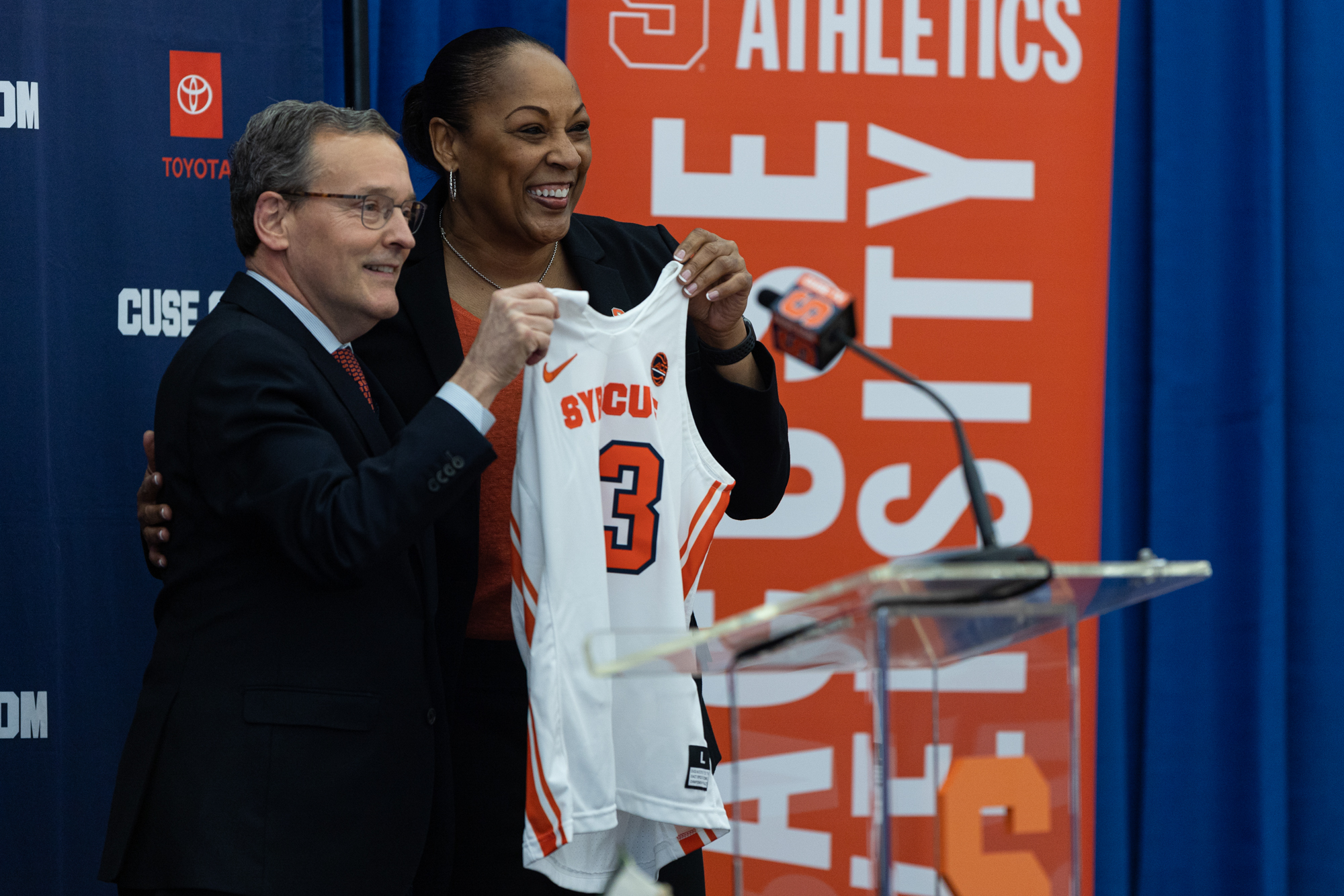Felisha Legette-Jack and SU athletic director John Wildhack hold up a jersey with Felisha's name on it in the Melo Center on March 28th, 2022.