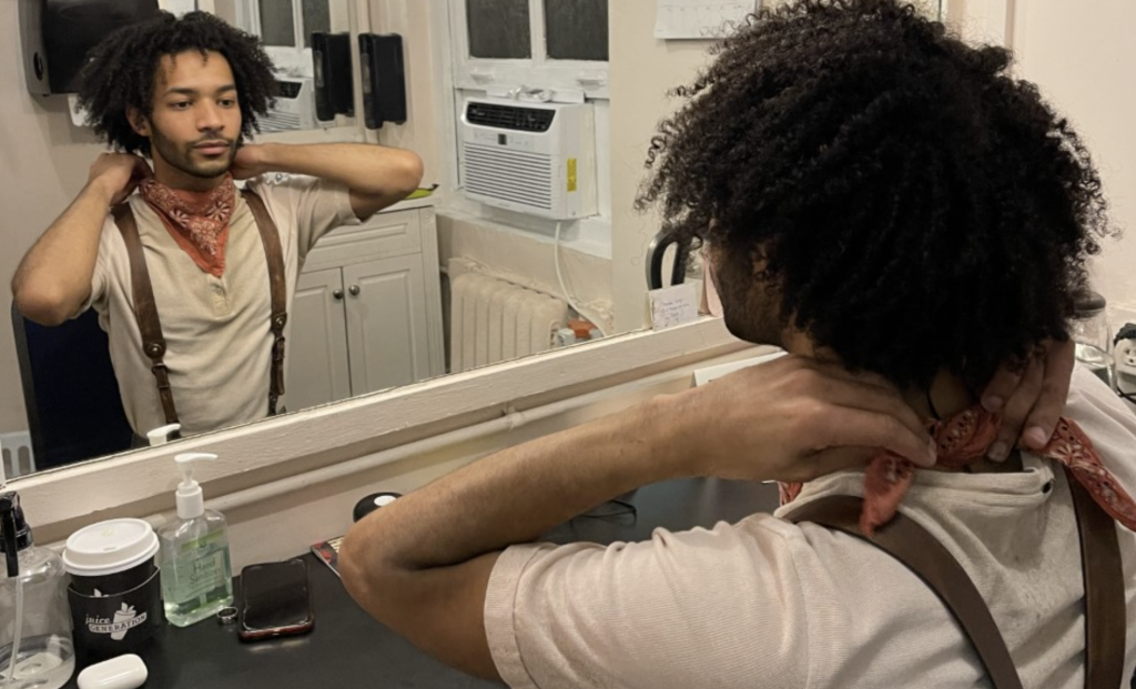 Actor Jordan Dobson gets ready backstage for his role as Orpheus