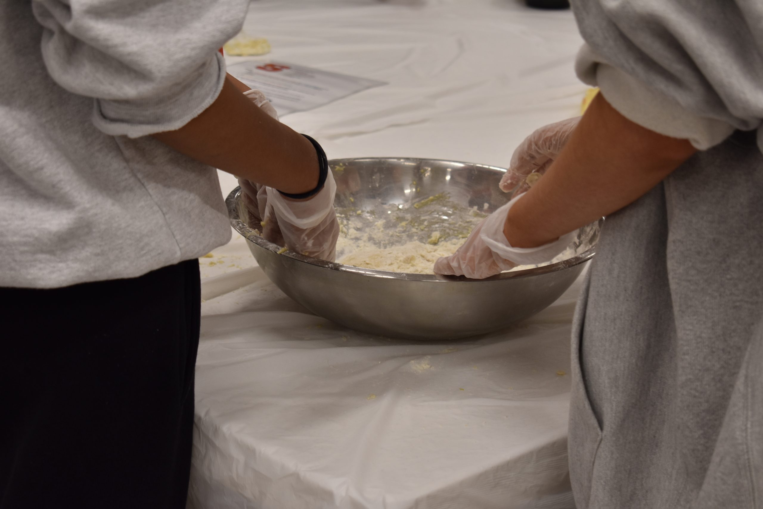 Students mix challah dough by hand at Challah for Hunger's bake event.