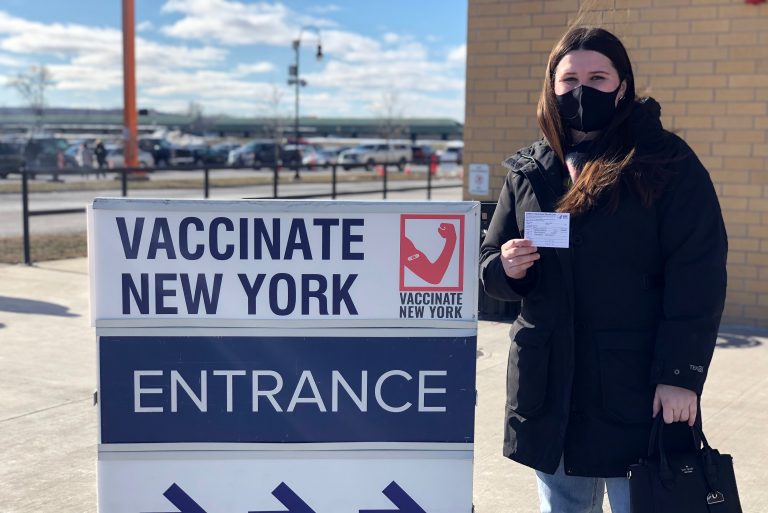 Leah Dunne holds her vaccination card after receiving her first dose of the COVID-19 vaccine at the New York State Fairgrounds.