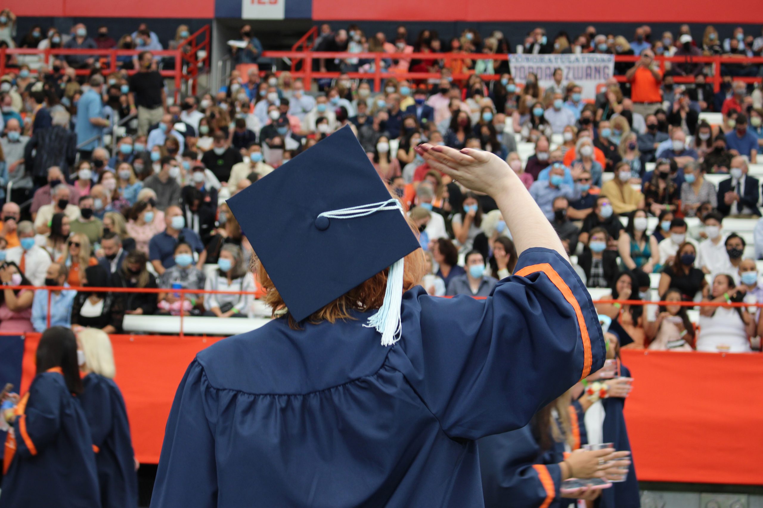 A 2020 SU graduate waves before the September 19, 2021 Commencement ceremony in the Dome on September 17th, 2021.