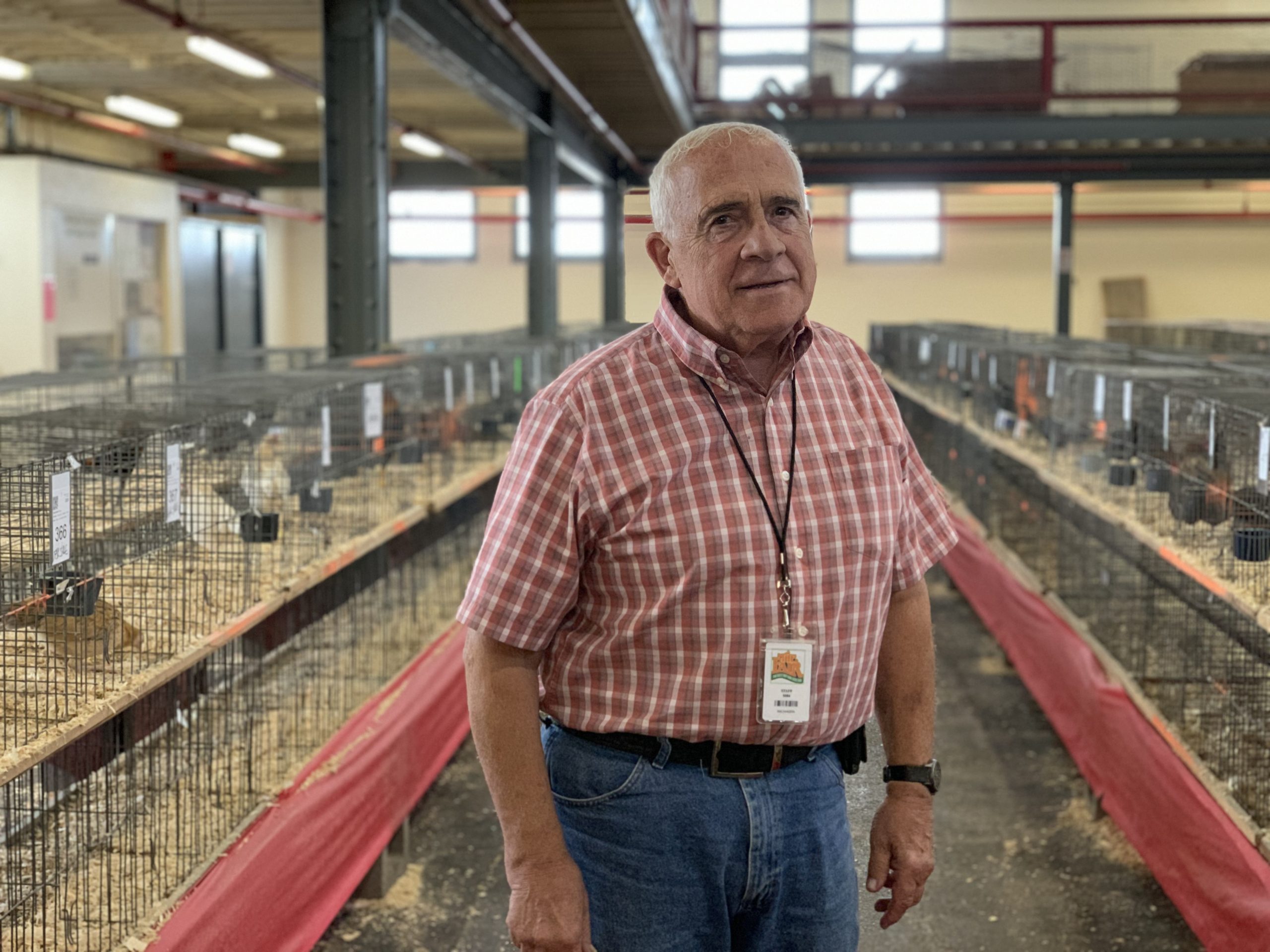 John Pierce, superintendent of the Poultry Building, poses in front of the flocks of chickens and ducks at the New York State Fairgrounds.