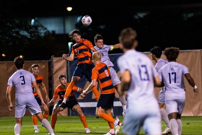 A member of the Syracuse Men's Soccer team leaps for a header versus Georgetown.