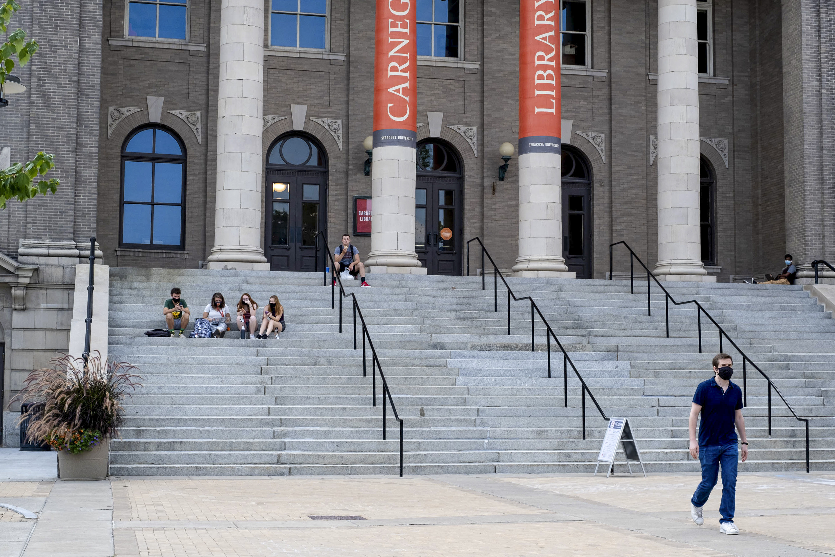 Small groups of students hang out on the steps of Carnegie Library on the first day of the fall semester.
