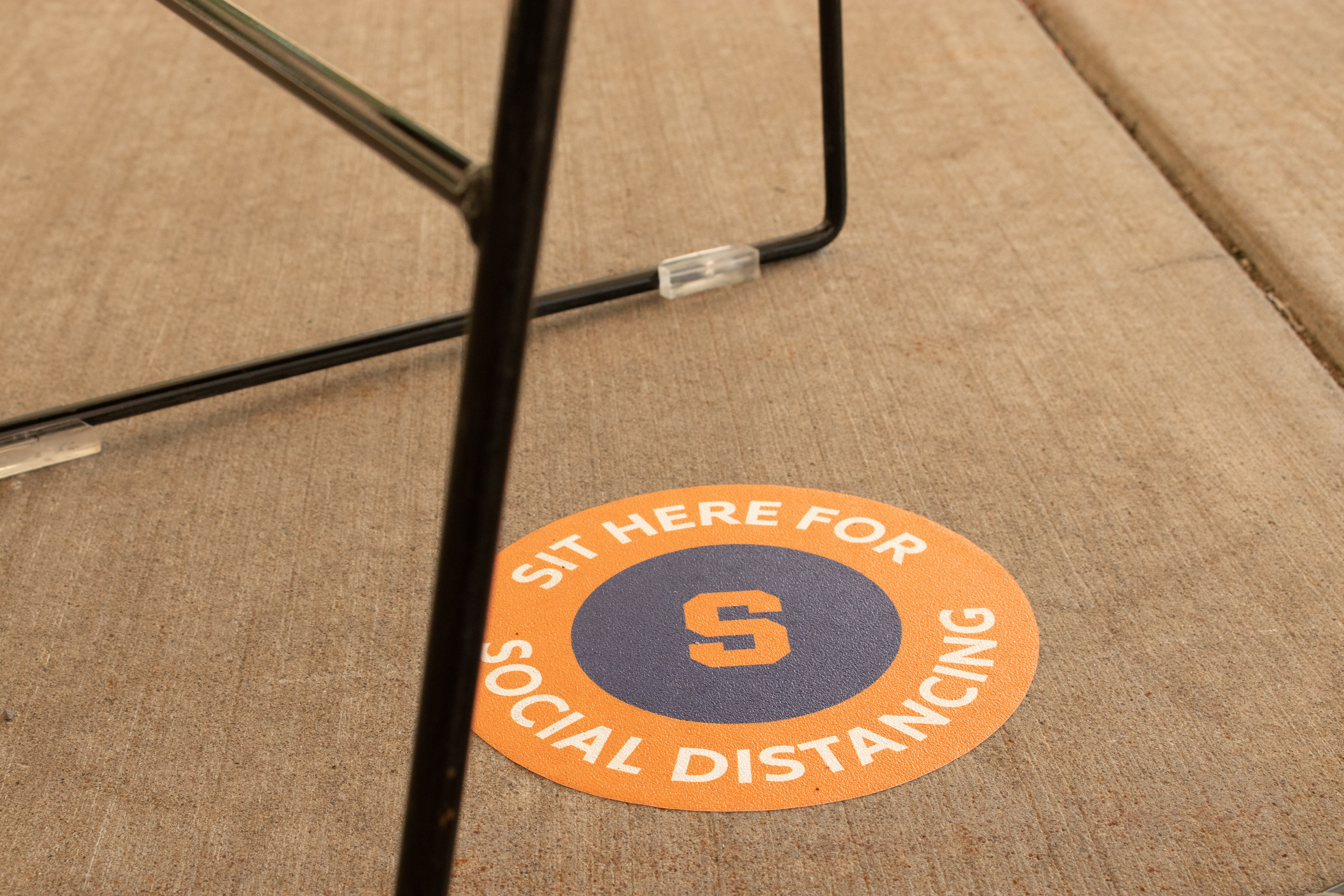 Signs designate social distancing safe locations on Syracuse University's campus.