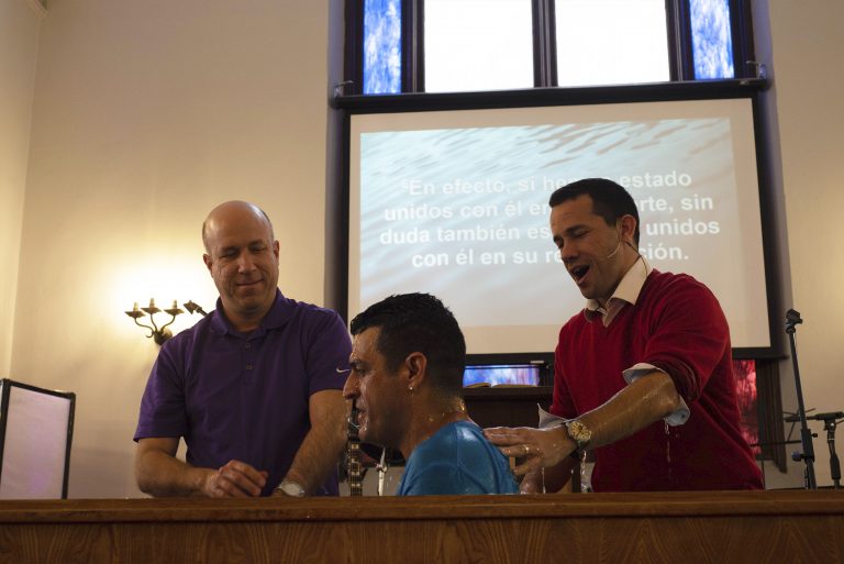 Pastor Reynier Martinez (right), baptizes member of the congregation