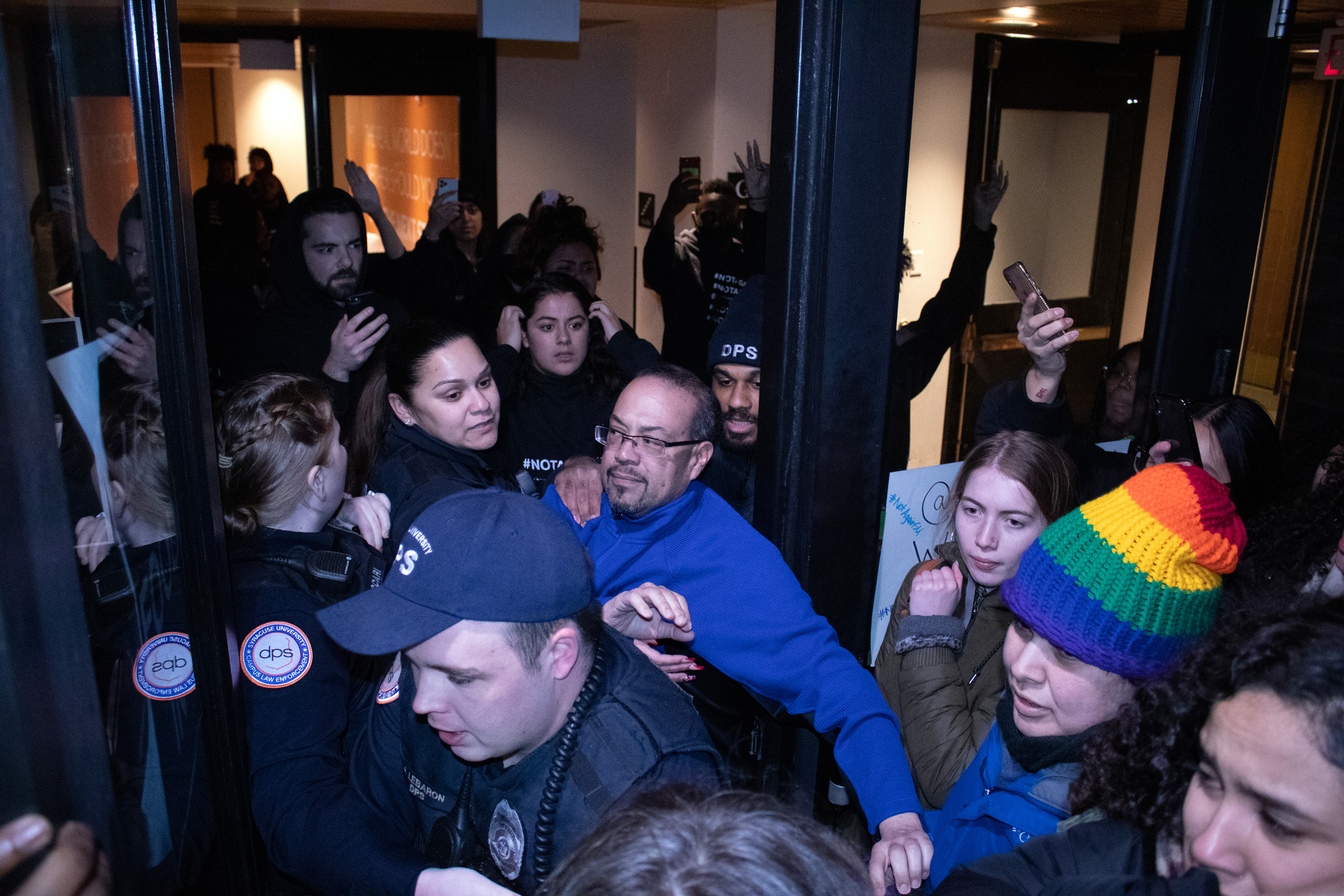 DPS campus security and Syracuse University administrative faculty attempt to hold protesters back as they attempt to push into Crouse Hinds Hall on the night of February 18, 2020.