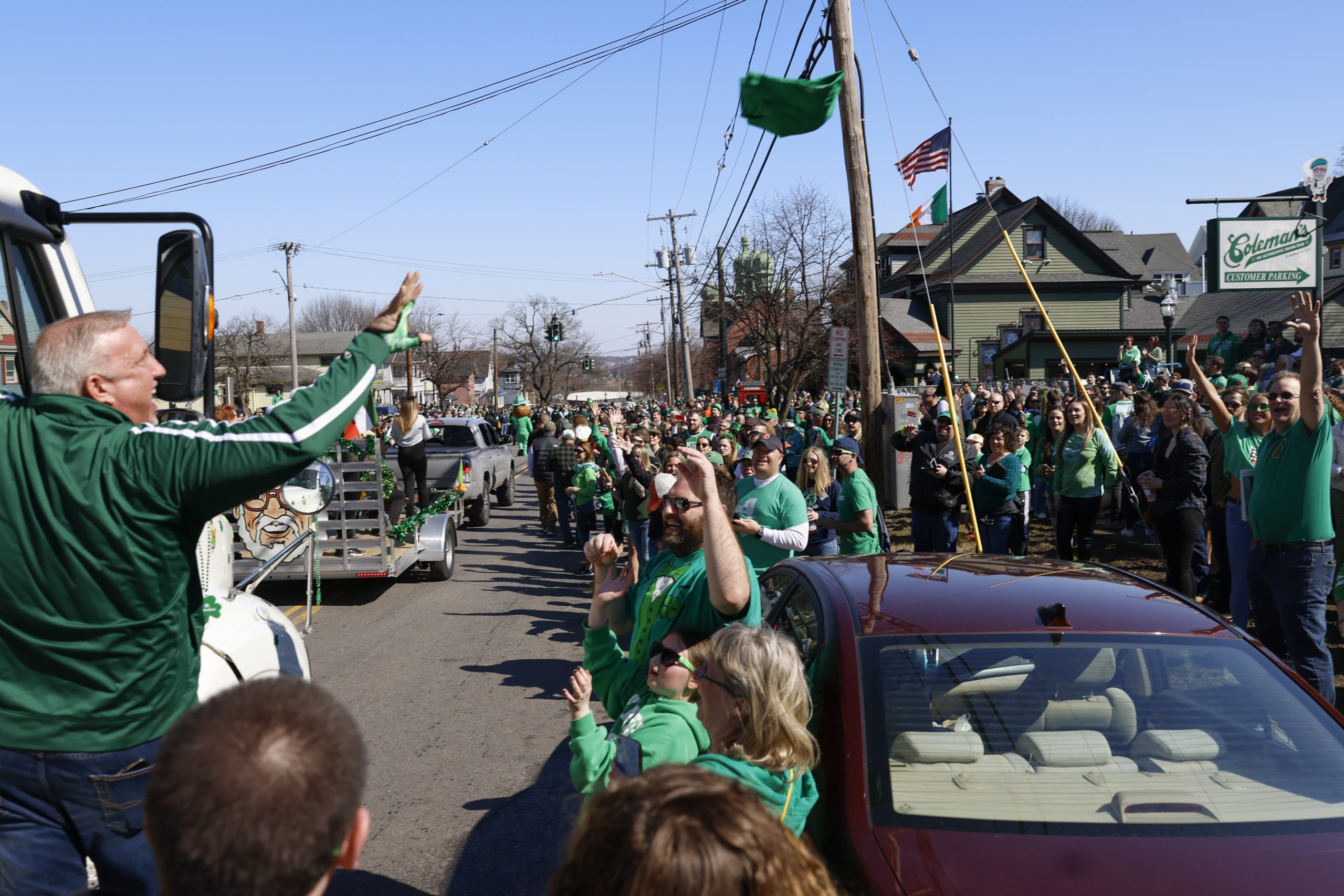 A man throws shirts and other memorabilia from the Coleman's green beer tanker to the crowd of people waiting for the festivities to begin.