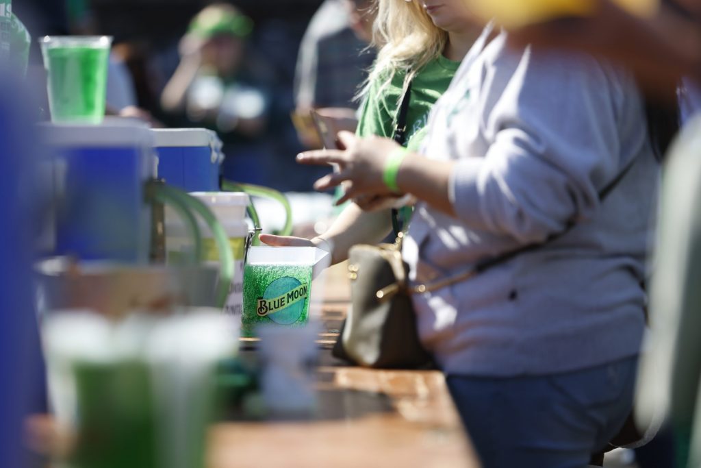 People line up at one of the many bars to refill their green-beer pitchers.