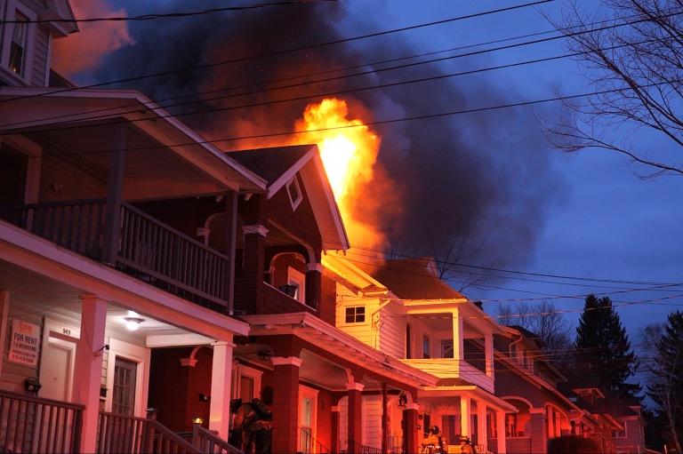 Flames and smoke shoot from the roof during a house fire on Ackerman Avenue on April 11, 2022.