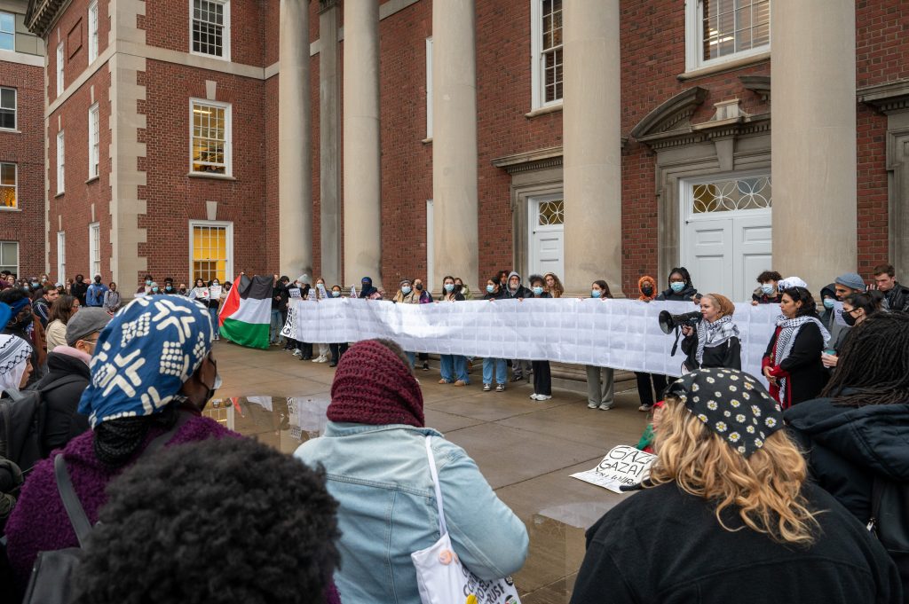 Syracuse University students carry a list of 6,728 names of Palestinians killed in Gaza in a span of 18 days outside of the Maxwell School of Citizenship and Public Affairs, November 9, 2023.