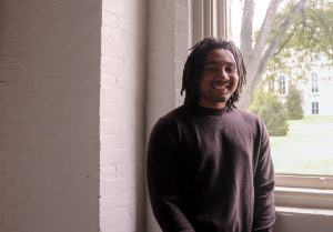 Syracuse University film graduate student Tevvon Hines stands by a window in his art studio in Smith Hall.