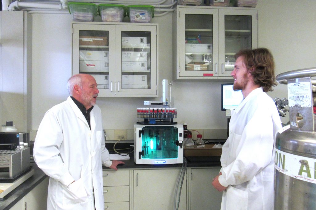 Driscoll and a student in the lab looking at water samples in the lab.