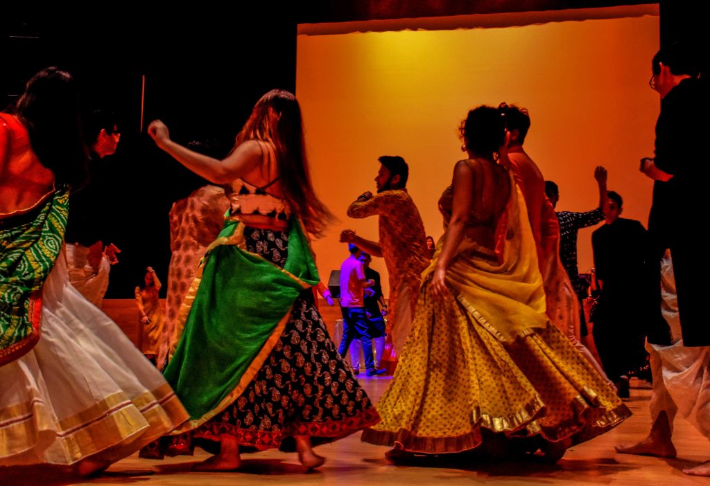 Dancers in beautifully colored traditional Gujarati attire, dancing to the desi-beats.