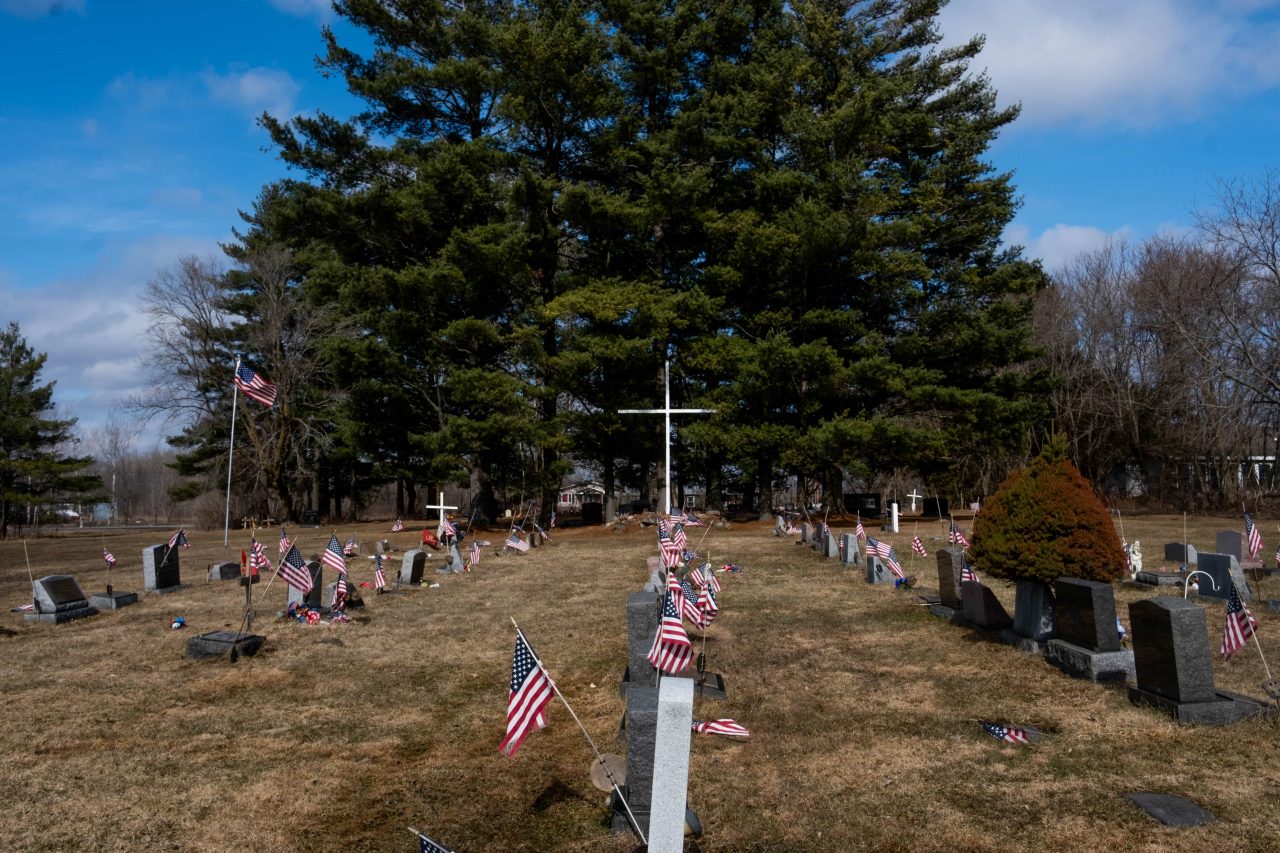The American Legion's cemetery is located less than a mile from the border of Quebec. A large white cross overlooks the dozens of gravestones that are decorated with both American and Mohawk iconography.