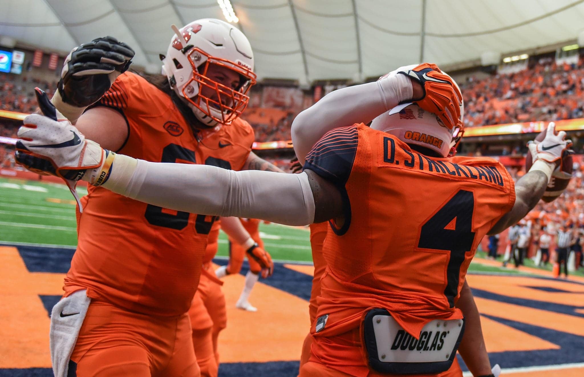 Syracuse University running back Dontae Strickland (4) celebrates a touchdown with his teammates during the Orange's 30-7 win over Florida State.