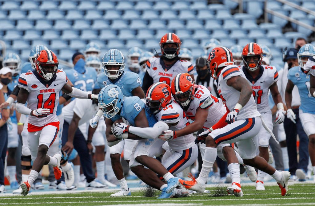 Syracuse defenders swarm to bring down UNC's Michael Carter (8) in first half action in Kenan Stadium Saturday, September 12, 2020 in Chapel Hill, N.C. Fans have been prohibited from attending the game due to the COVID-19 virus.