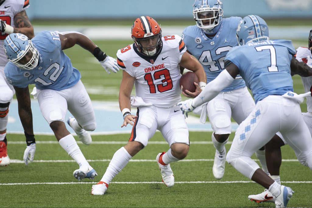 Syracuse quarterback Tommy DeVito (13) looks for running room against North Carolina's Eugene Asanti (7) during the second quarter in Kenan Stadium on Saturday, September 12, 2020 in Chapel Hill, N.C.
