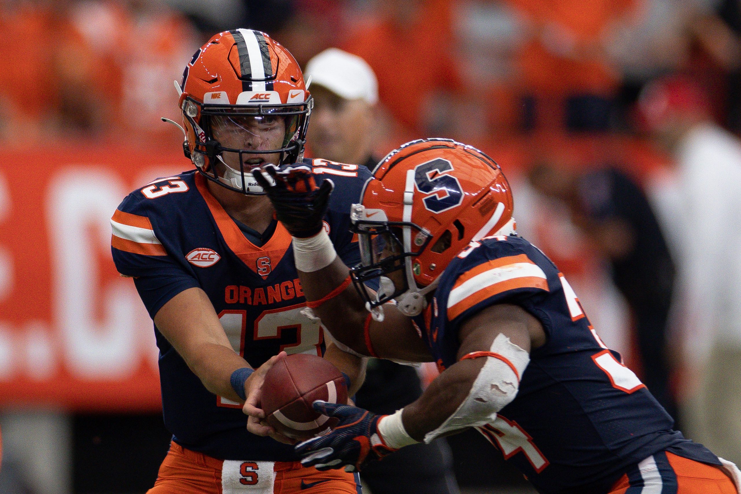 Syracuse’s Tommy DeVito (13) hands the ball off to Sean Tucker during an NCAA football game against Rutgers, Saturday, at the Carrier Dome.