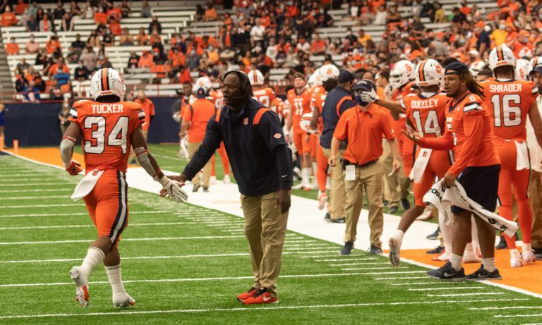 Syracuse University football coach Dino Babers high fives Sean Tucker (34) as Tucker returns to the sidelines during a NCAA football game against University of Albany, Saturday, at the Carrier Dome.