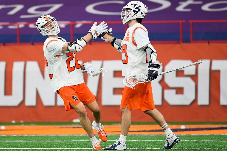 Syracuse Orange attackman Chase Scanlan (22) and attackman Stephen Rehfuss (29) celebrate a goal against the Vermont Catamounts during the first half at the Carrier Dome.