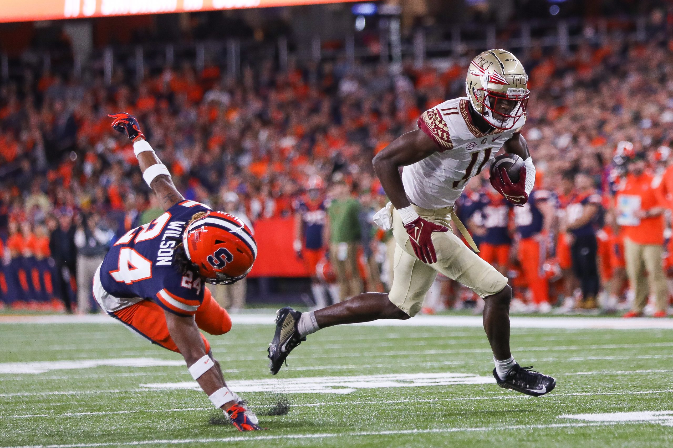 Florida State's Malik McClain (11) escapes Syracuse's Jeremiah Wilson (24) for a touchdown during an ACC football game Saturday night at the JMA Wireless Dome.