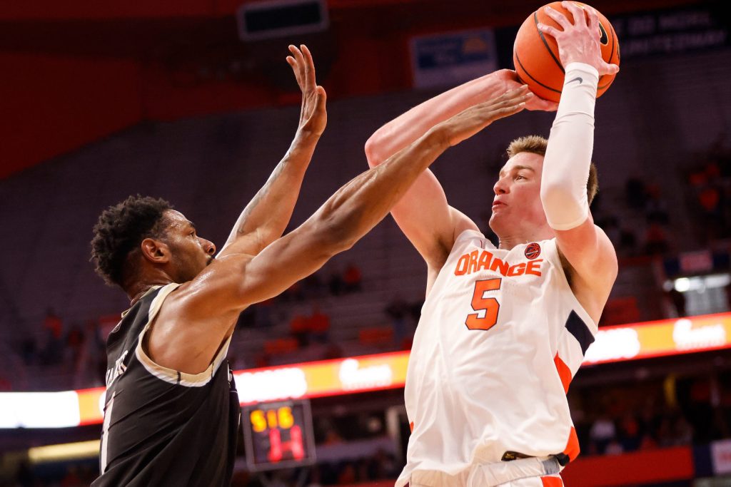 Syracuse's Justin Taylor (5) fades away to release a shot over Bryant's Antwan Walker/ Taylor scored a game-high 25 points to pace the orange.
