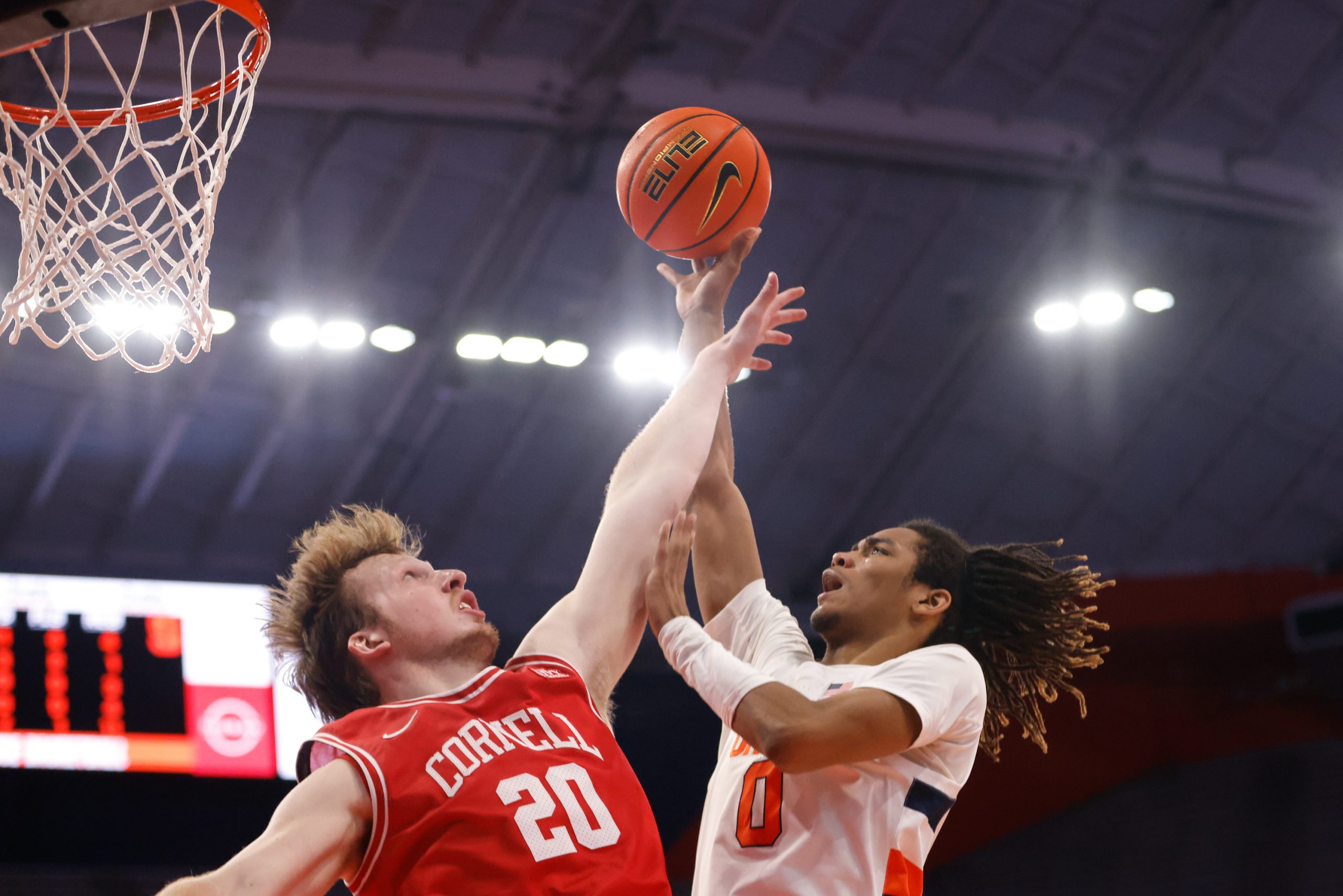 Syracuse's Chris Bell (0) puts up a close-range shot over the outstretched arm of Cornell's Sean Hansen during an NCAA men's basketball game on Saturday at JMA Wireless Dome.