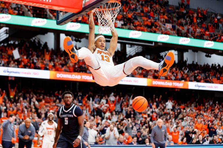 Benny Williams #13 of the Syracuse Orange dunks over Jay Heath #5 of the Georgetown Hoyas during the second half at JMA Wireless Dome on December 10, 2022 in Syracuse, New York.