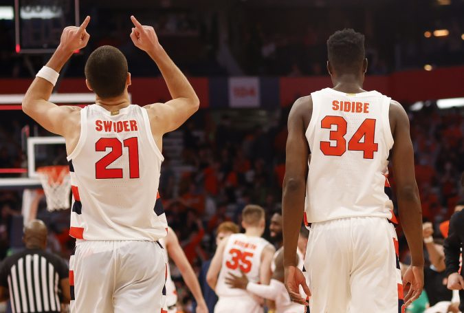 Syracuse's Cole Swider points to the sky as he walks off the court with Bourama Sidibe after the Orange defeated Georgia Tech, 74-73, during overtime in an ACC men's basketball game on Monday night at the Carrier Dome.