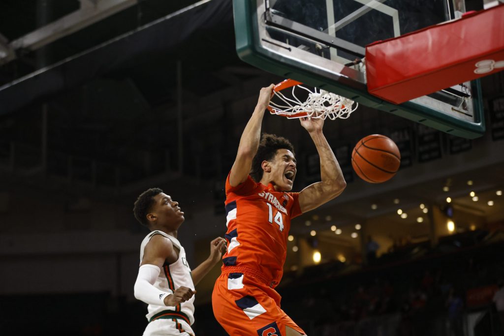Syracuse's Jesse Edwards lets out a scream and dunks as Miami's Anthony Walker can only watch.
