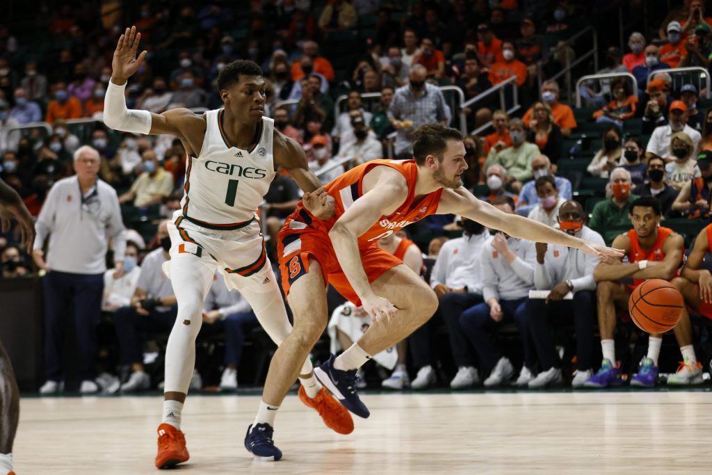Syracuse's Jimmy Boeheim (right) tries to keep possession of a loose ball headed toward the baseline with Miami's Anthony Walker behind him.