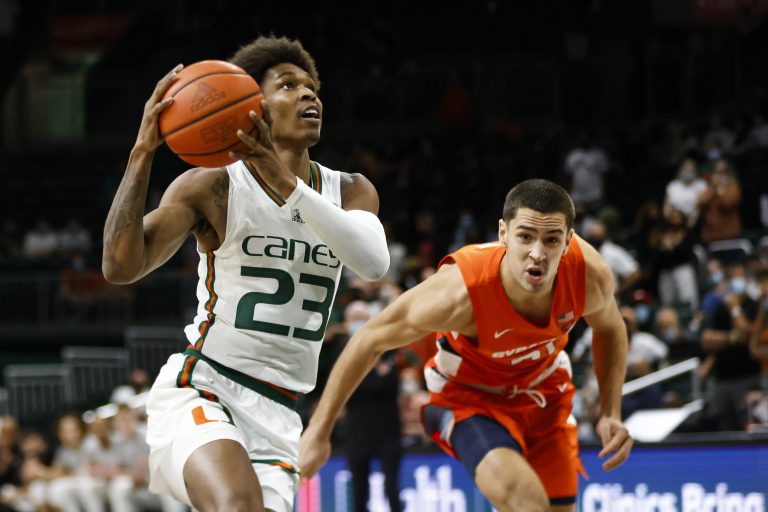 Miami's Kameron McGusty (23) looks up toward the basket as he coasts in for two points after making a move past Syracuse's Cole Swider during an ACC men's basketball game on Wednesday at Watsco Center in Coral Gables, Florida.