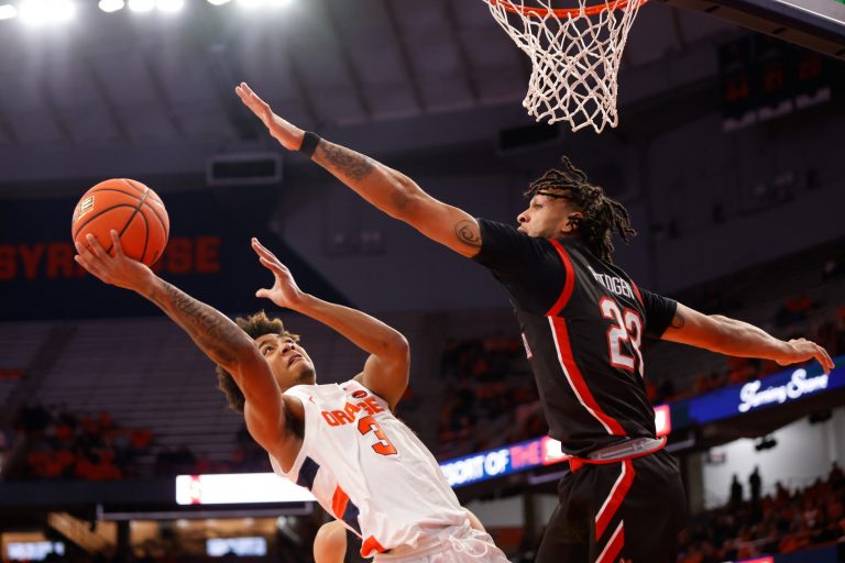 Northeastern's Joe Pridgen (23) meets Syracuse's Judah Mintz (3) at the rim and tries to block the shot during an NCAA men's basketball game on Saturday at the JMA Wireless Dome.